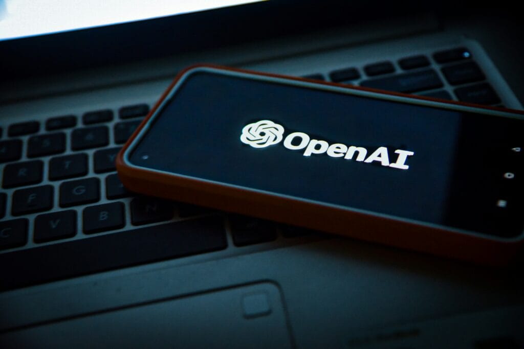 OpenAI on a smartphone, sitting on a laptop
