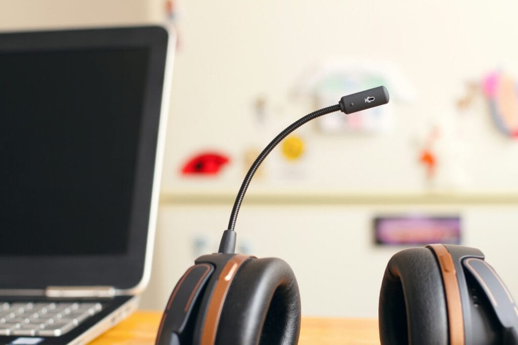 A headset resting beside a laptop on a desk