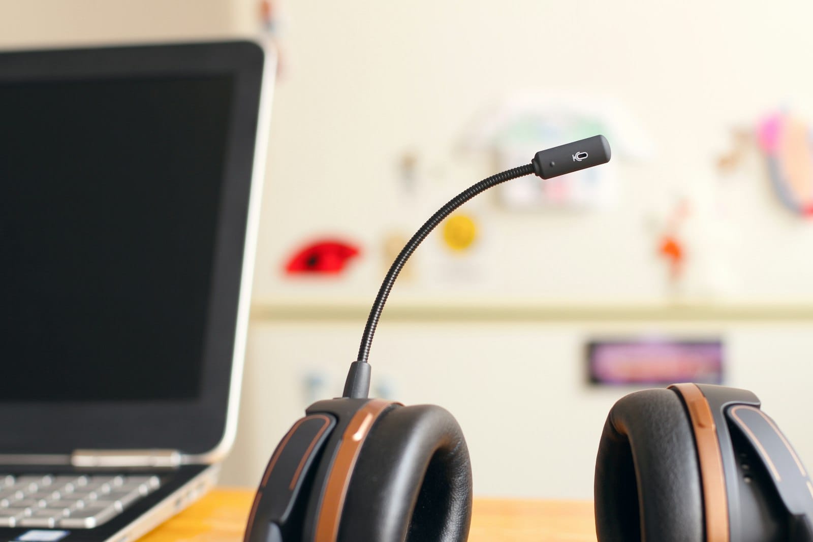 A headset resting beside a laptop on a desk